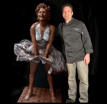 A man standing next to a statue of a woman.