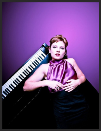 Woman posing by piano on purple background.