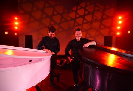 Two men with white and black pianos.