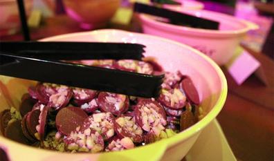 Bowl of chocolates with serving tongs.