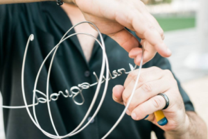 A person holding a wire with the word " bourgeois ".