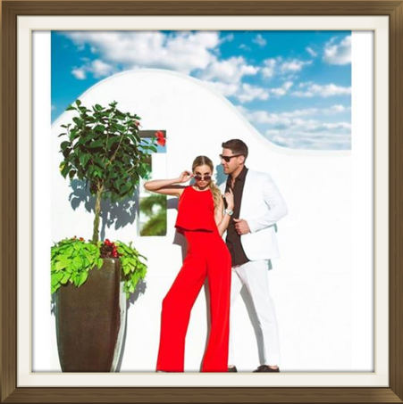 Stylish couple posing by white building.