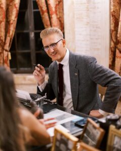 A man in a suit and tie sitting at a table.